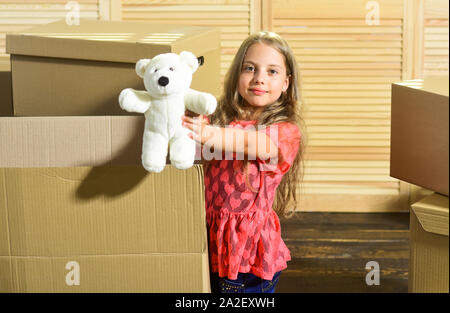 Only true friend. Girl child play with toy near boxes. Move out concept. Prepare for moving. Moving out. Moving routine. Packaging things. Stressful s Stock Photo