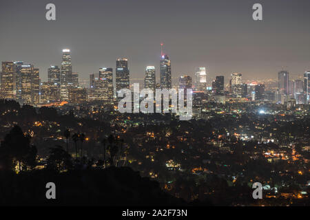 Los Angeles, California, USA - October 2, 2019:  Early morning night view of downtown office towers and hillside homes. Stock Photo