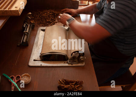 Rolling machine waiting for the man's hands to accommodate pieces of tobacco leaf to roll the cigar Stock Photo
