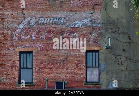 old faded coke sign painted on a brick wall Stock Photo