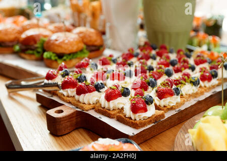 Desserts and burgers on table, hotel dinner board Stock Photo
