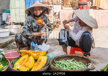 Hoi An, Vietnam - March 3rd 2010: Women selling fruit and vegetables on a market. Markets are held every day. Stock Photo