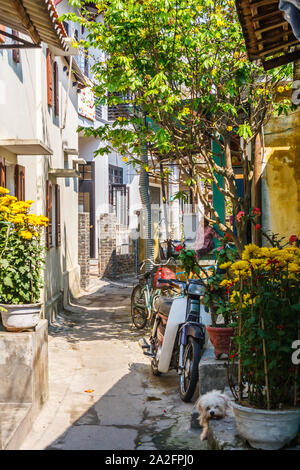 Hoi An, Vietnam - March 3rd 2010: Typical narrow street in the town. The town is a popular tourist destination. Stock Photo