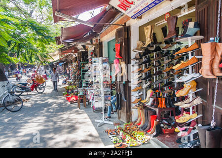 Hoi An, Vietnam - March 3rd 2010: Shop selling shoes. This is a typical shopping street in the town. Stock Photo