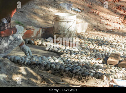 preparation of the substrate for the creation of a cobblestone path in a public park Stock Photo