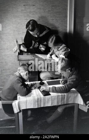 Mitglieder einer kinderreichen Familie helfen sich gegenseitig, Deutsches Reich 1930er Jahre. Members of an extended family helping one another, Germany 1930s. Stock Photo