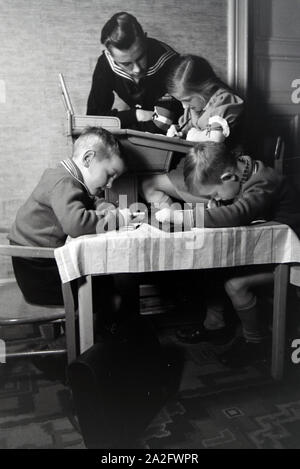 Mitglieder einer kinderreichen Familie helfen sich gegenseitig, Deutsches Reich 1930er Jahre. Members of an extended family helping one another, Germany 1930s. Stock Photo