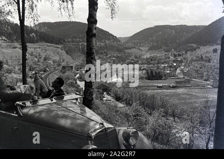 Ein junges Paar und ihr Hund bei einer Spazierfahrt mit dem Mercedes Cabrio in Hirsau im Nordschwarzwald, Deutschland 1930er Jahre. A young couple and their dog driving through Hirsau in the Northern Black Forest in a Mercedes convertible, Germany 1930s. Stock Photo