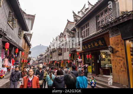 Hunan, China, 14 Nov 2011: Busy street of tourists in Phoenix Ancient Town with architecture dating back to the 18th century. Stock Photo