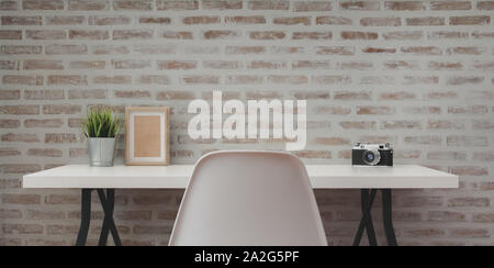 Loft modern workplace with white wooden table with office supplies and copy space with brick wall background Stock Photo