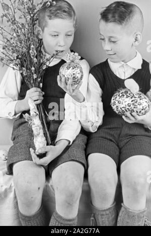 Zwei Jungen mit Ostedekoration, Deutschland 1930er Jahre. Two boys at a table with easter decoration, Germany 1930s. Stock Photo