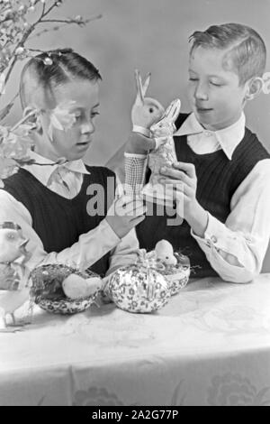 Zwei Jungen mit Ostedekoration, Deutschland 1930er Jahre. Two boys at a table with easter decoration, Germany 1930s. Stock Photo