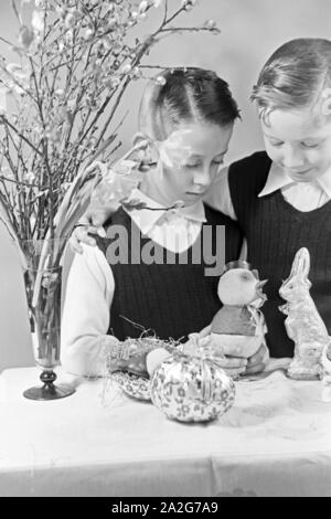 Zwei Jungen mit Ostedekoration, Deutschland 1930er Jahre. Two boys at a table with easter decoration, Germany 1930s. Stock Photo