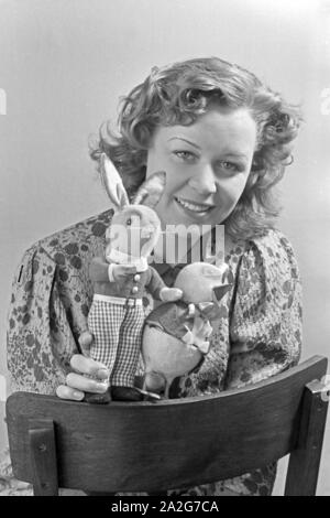 Porträt eines jungen Mädchens, Osterdekoration in den Händen haltend, Deutschland 1930er Jahre. Portrait of a young girl holding some easter decoration in her hands, Germany 1930s. Stock Photo