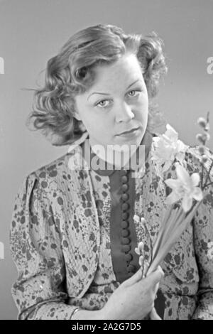 Porträt eines jungen Mädchens, Osterdekoration in den Händen haltend, Deutschland 1930er Jahre. Portrait of a young girl holding some easter decoration in her hands, Germany 1930s. Stock Photo