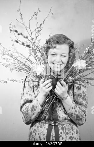 Porträt eines jungen Mädchens, Osterdekoration in den Händen haltend, Deutschland 1930er Jahre. Portrait of a young girl holding some easter decoration in her hands, Germany 1930s. Stock Photo