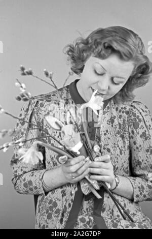 Porträt eines jungen Mädchens, Osterdekoration in den Händen haltend, Deutschland 1930er Jahre. Portrait of a young girl holding some easter decoration in her hands, Germany 1930s. Stock Photo