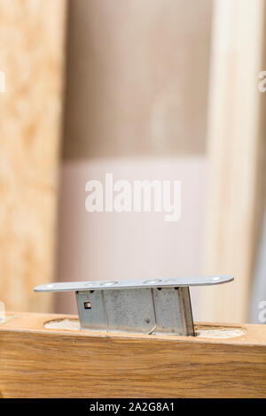 Mortise lock is inserted halfway into the old a wooden door. Stock Photo
