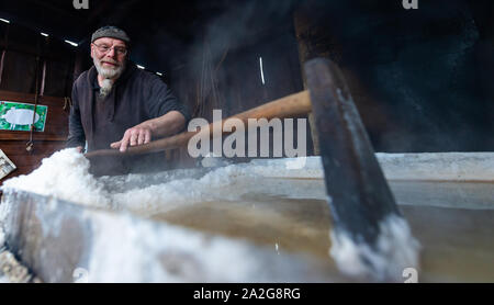 30 September 2019, Lower Saxony, Lüneburg: In a boiling hut Mimke Koch shows as a salt boiler how it was produced in the Middle Ages. Salt secured Lüneburg's prosperity and power for centuries. (to dpa 'Lüneburg and the salt' of 03.10.2019) Photo: Philipp Schulze/dpa Stock Photo