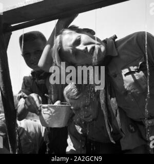 Hitlerjungen löschen ihren Durst an einem Brunnen in der Nähe von Spitz in Niederösterreich, Österreich 1930er Jahre. Hitler youths drinking from a well at Spitz, Lower Austria, Austria 1930s. Stock Photo