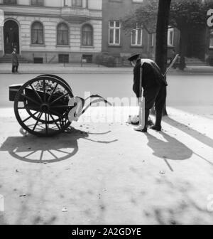 Ein Straßenfeger bei der Arbeit, Deutsches Reich 1930er jahre. A street cleaner working, Germany 1930s. Stock Photo