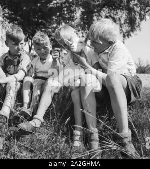 Kinder spielen mit einem Lamm, Deutschland 1930er Jahre. Children playing with a little lamb, Germany 1930s. Stock Photo