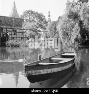 Das Ruderboot 'Möwe' liegt auf dem Wasser in Soest mit Blick auf den St. Patrokli Dom und die St. Petri Kirche, Deutschland 1930er Jahre. A rowing boat lying on the water at Soest in Westfalia, Germany 1930s.