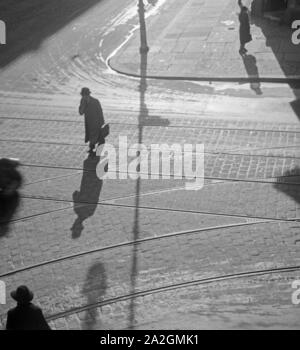 Die Menschen in Berlin werfen lange Schatten, Deutschland 1930er Jahre. people at a street in Berlin with their shadows, Germany 1930s. Stock Photo