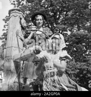 Zwei junge Frauen an einem Brunnen in der Wachau in Österreich, Deutschland 1930er Jahre. Two young women in front of a fountain at the Wachau area in Austria, Germany 1930s. Stock Photo