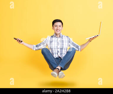 young man holding phone and floating in the air Stock Photo