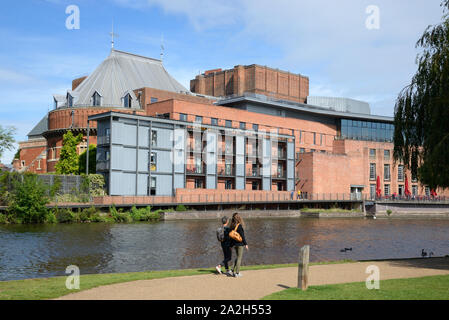 Two Female Tourists Walk Along the River Avon in front of the Royal Shakespeare Theatre on the Banks of the River Avon Stratford-upon-Avon Stock Photo