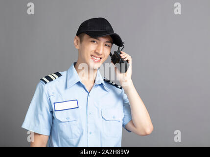 Male security guard using portable radio transmitter Stock Photo