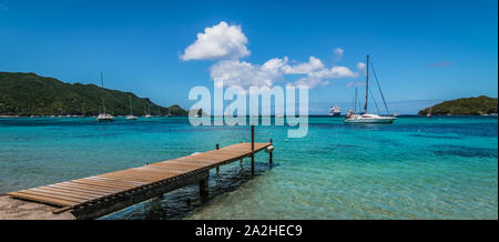 Panoramic sea and harbor view with wooden pier at the beach of Bequia, St Vincent and the Grenadines. Stock Photo