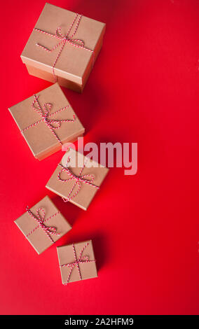 Five different sizes Christmas gift boxes on the red background. Stock Photo