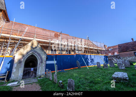 Re-tiling the roof of an ancient church at Catsifled, East Sussex, England Stock Photo