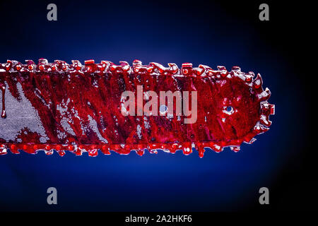 detail of a chain saw covered in blood. Image suitable for horror or halloween theme. Stock Photo