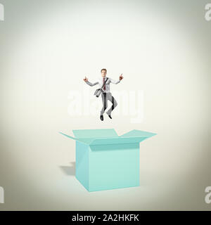 Happy and successful man jumps out of the box. concept of different and creative thinking. winning attitude. Stock Photo
