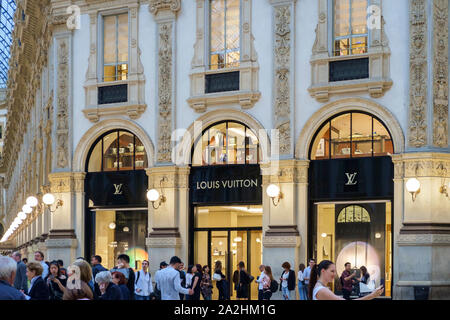 Milan, Italy August 2019. Galleria Vittorio Emanuele near Duomo, group of tourists standing in front of Louis Vuitton taking pictures. Stock Photo