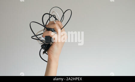Black and white cables in a woman's hand on isolated background Stock Photo