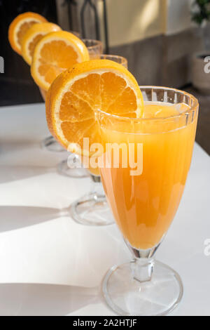 Four glasses of freshly squeezed orange juice. Stock Photo