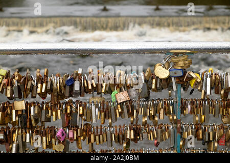 Lovelocks or love locks on the Bridge over the River Wye in Bakewell, Derbyshire. A lovelock or love padlock  which is inscribed with the intials of two lovers Stock Photo