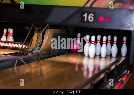 Close up of alley at bowling club. pin bowling alley background. Closeup of ten pin row on a lane, night light and sphere ball . Victory concept compe Stock Photo