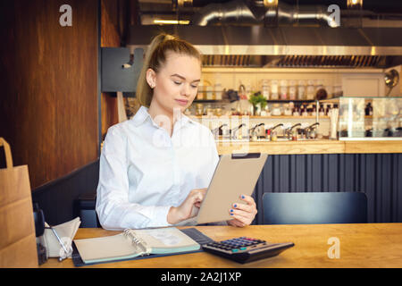 Small business owner using digital tablet to pay taxes online Stock Photo