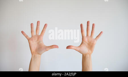 Hands and ten fingers of women raised up in the air on a white background Stock Photo