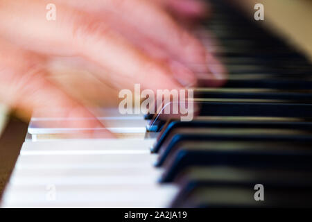 Blurred hand playing the piano close-up. Long exposure. Stock Photo