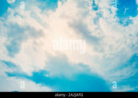 sun behind the clouds in blue sky in summer day. Stock Photo