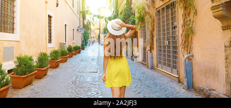 Back view of tourist woman holding hat at Trastevere in Rome, Italy. Panoramic banner view. Stock Photo