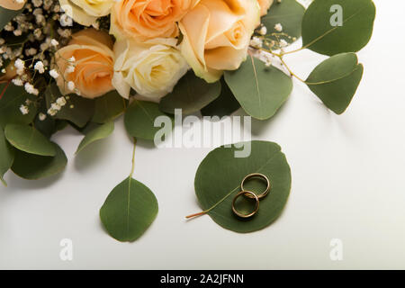 Two golden rings on green leaves on background Stock Photo
