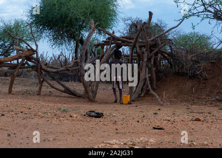 Turmi, Ethiopia - Nov 2018: Hamer tribe kids playing with self made truck from a water canister. Omo Valley Stock Photo