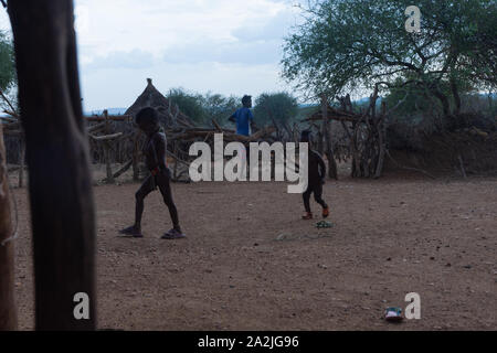 Turmi, Ethiopia - Nov 2018: Hamer tribe kids running the the yard in the rain Stock Photo